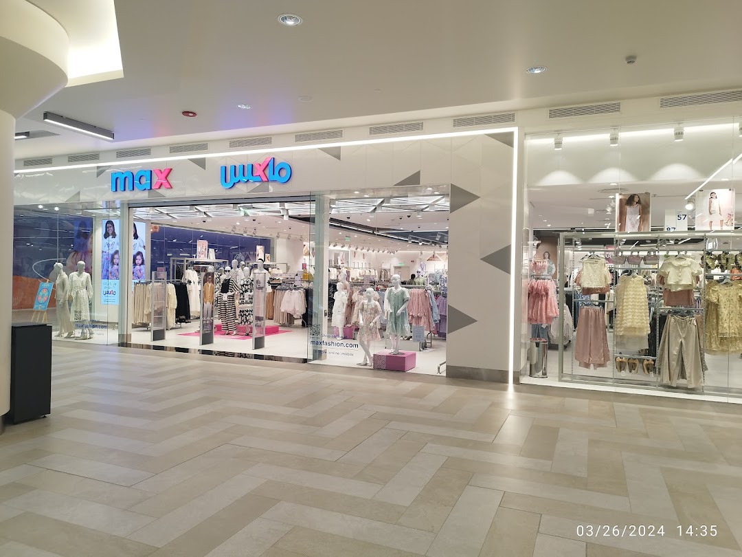 The Max fashion store entrance with mannequins displaying clothing and the store's logo.