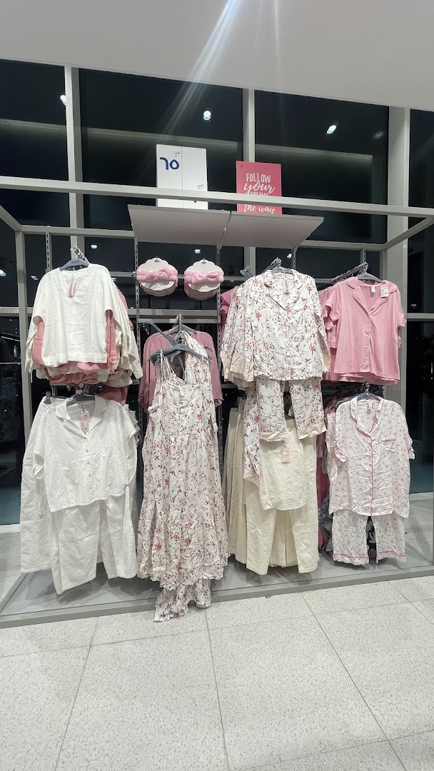 A display of women's sleepwear and loungewear in white and pink floral prints.
