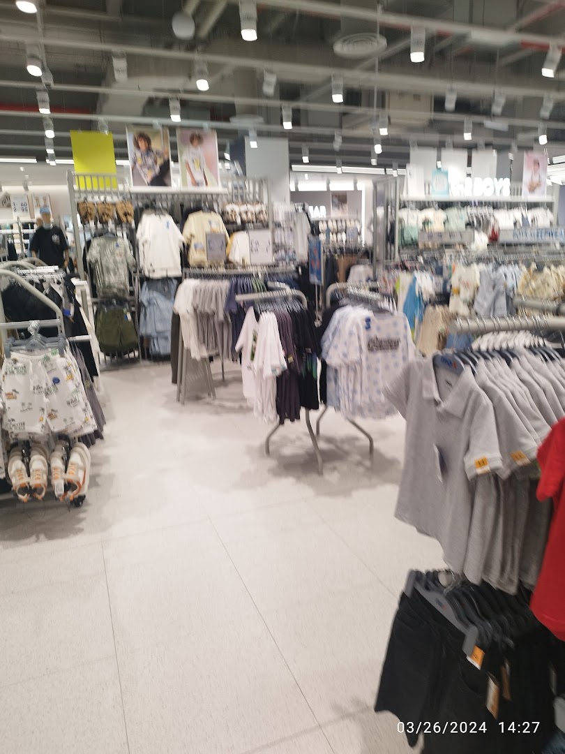 Interior view of a clothing store with racks of apparel and displays.