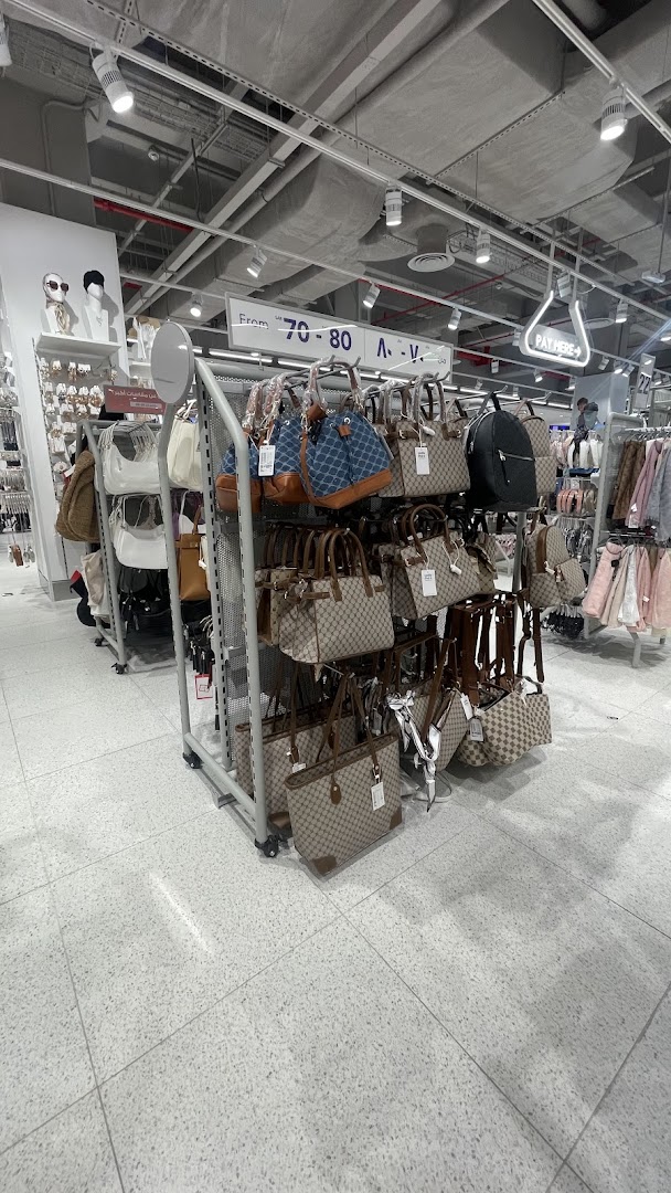 A display of various handbags and backpacks for sale in a retail store.
