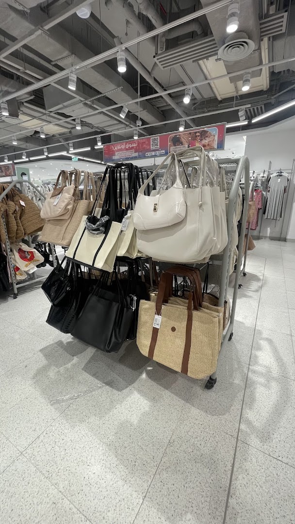 A display of various handbags, including tote bags and shoulder bags, in different colors and materials.