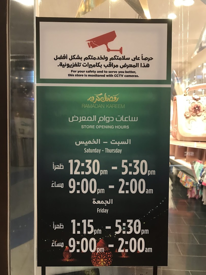 A sign displays store opening hours and a CCTV camera warning for Monsoon Accessorize.