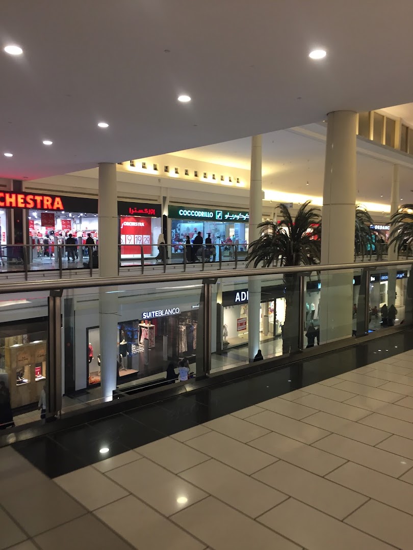 A view of various shops on two levels of a modern shopping mall.