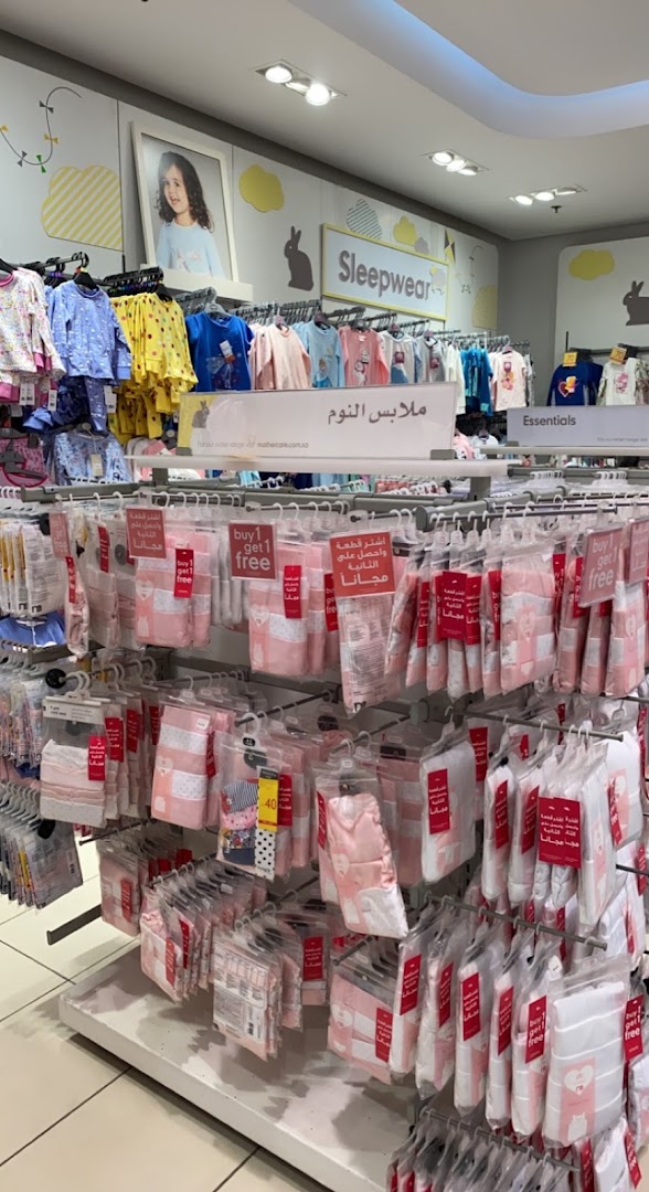 Mothercare shop interior displaying sleepwear and essentials with 'buy 1 get 1 free' promotions.