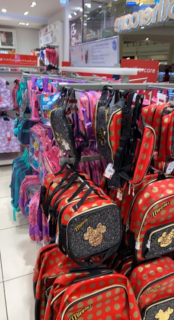 A display of Minnie Mouse themed backpacks and lunch bags in red with gold polka dots.