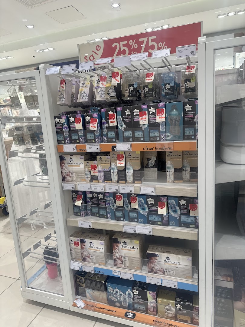 A display of baby bottles and feeding accessories from Mothercare, with a sale sign.