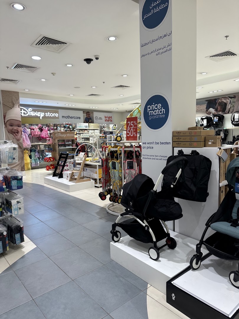 Interior view of a Mothercare store showcasing baby products and a price match guarantee banner.