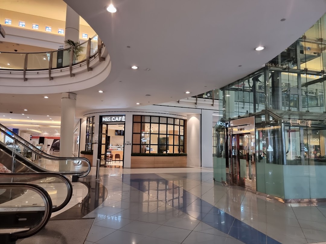 The M&S Cafe is visible in a modern shopping mall with escalators and glass elevators.