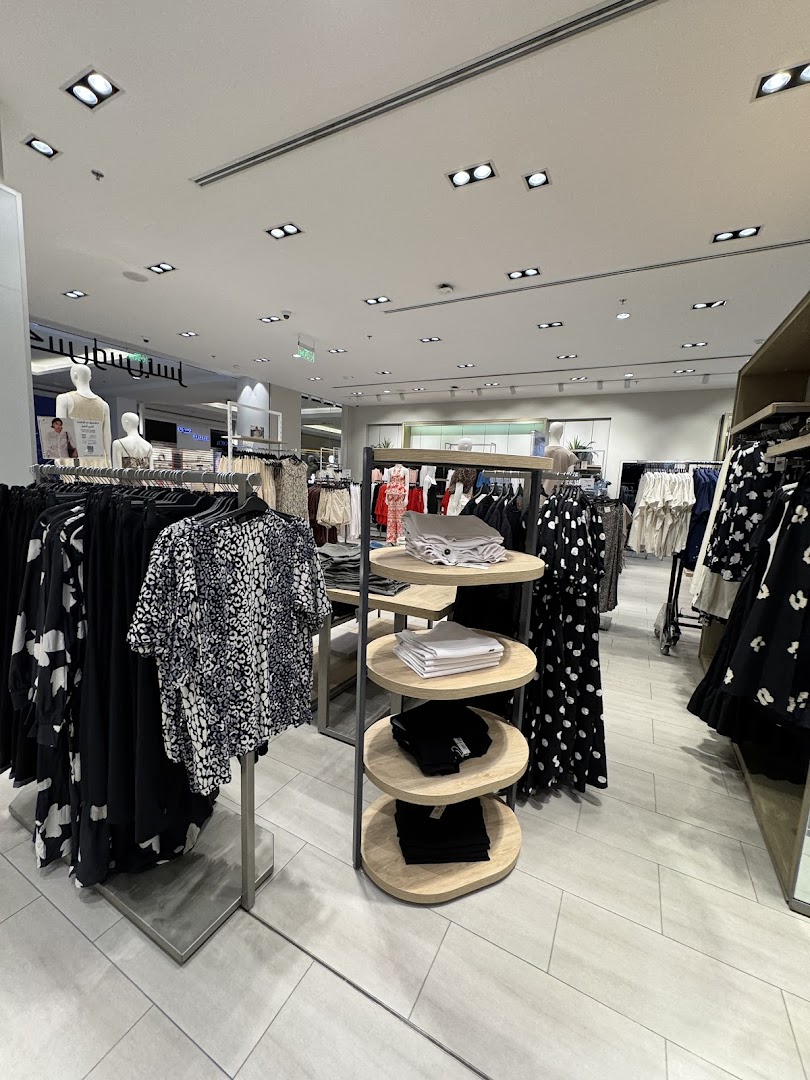 Interior view of a clothing store with mannequins and racks of apparel.