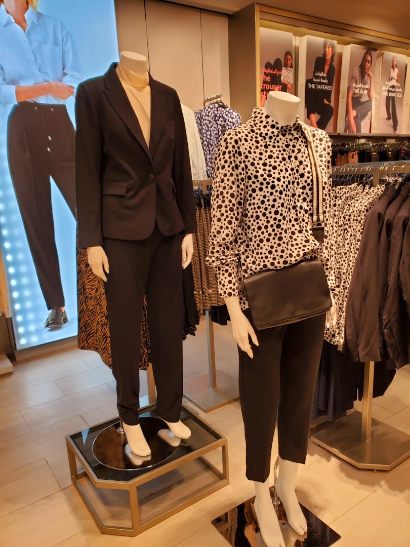 Mannequins display stylish outfits, showcasing tailored suits and patterned shirts.