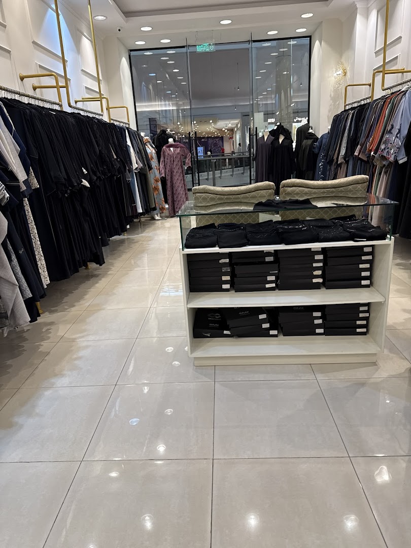 Interior view of a clothing store showcasing a wide selection of abayas and modest fashion.