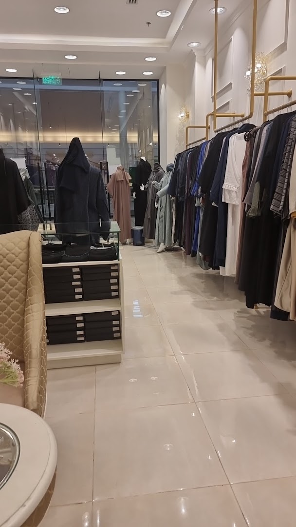 Interior view of a clothing store showcasing abayas and modest fashion on racks and mannequins.