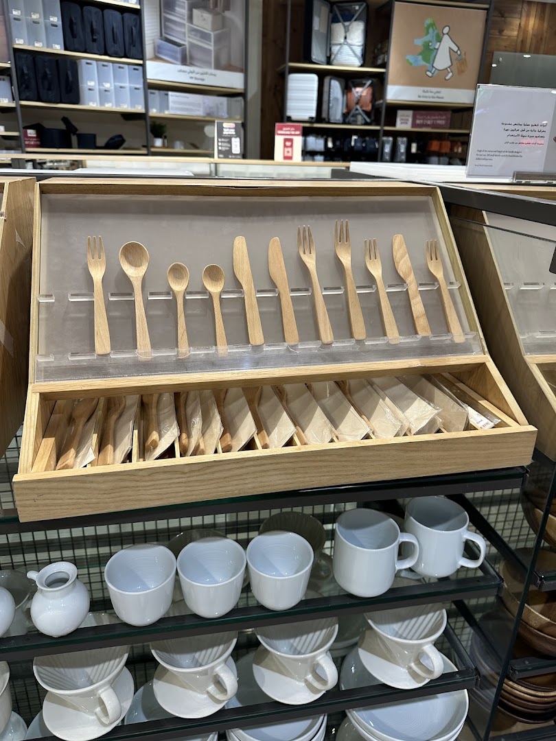 Muji store display featuring wooden cutlery and ceramic mugs.