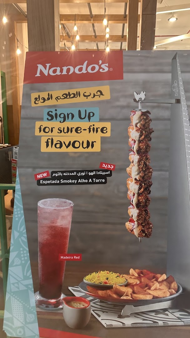 A Nando's advertisement featuring a new Espetada Smokey Alho A Torre dish and Madeira Red drink.