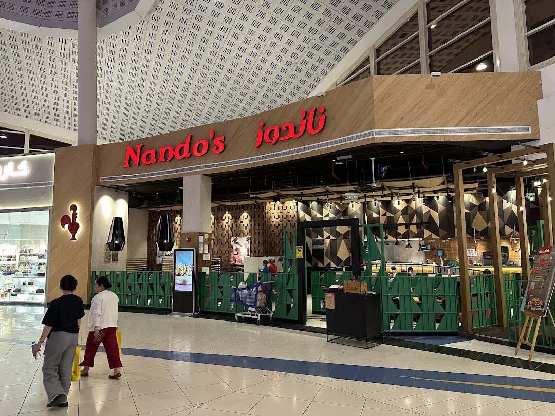 The exterior of a Nando's restaurant with its distinctive red logo and a rooster emblem.