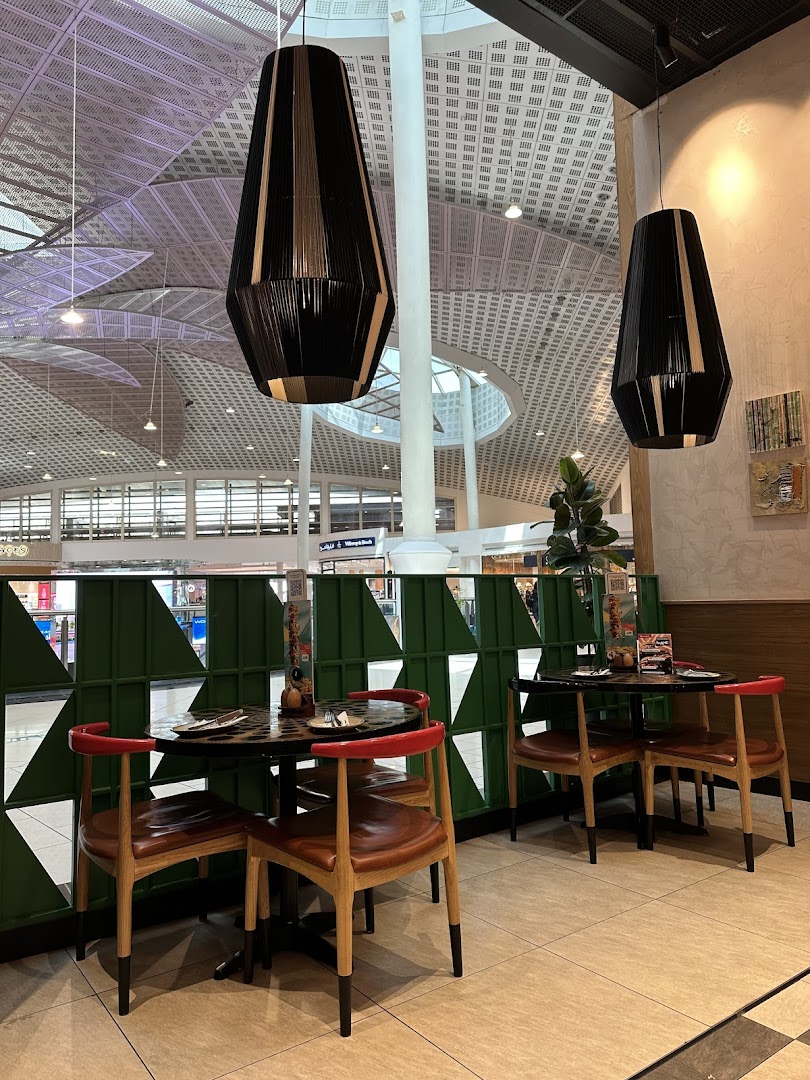 Interior shot of Nandos restaurant with tables, chairs, and modern pendant lights.