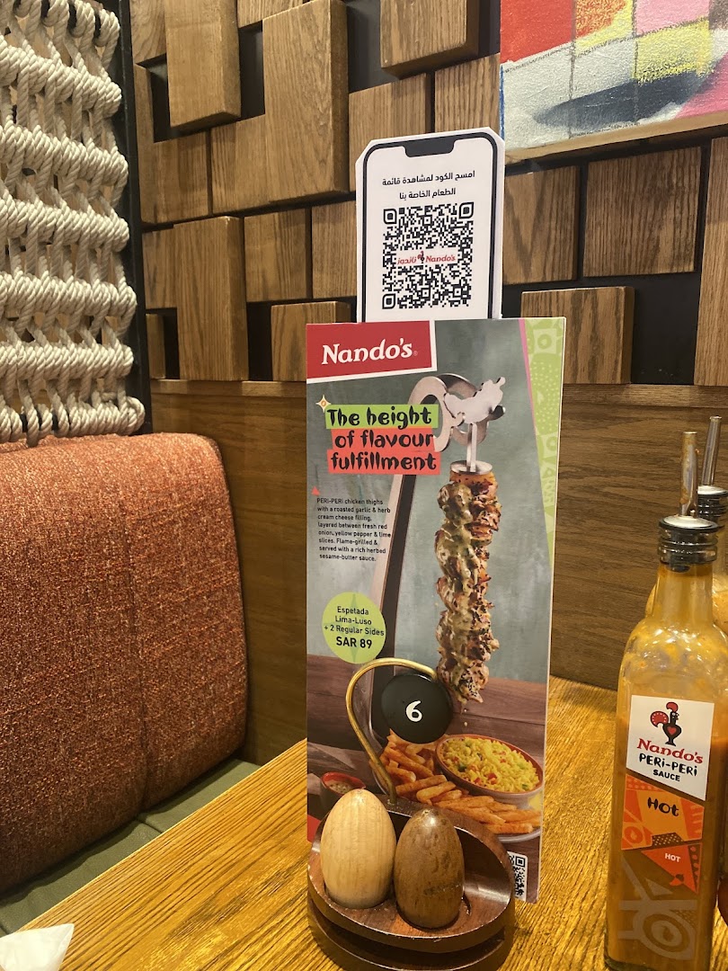 A Nando's menu featuring a PERI-PERI chicken dish and a QR code for the full menu.