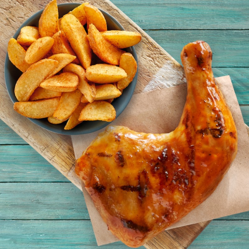 A delicious grilled chicken leg quarter served with a side of golden potato wedges.