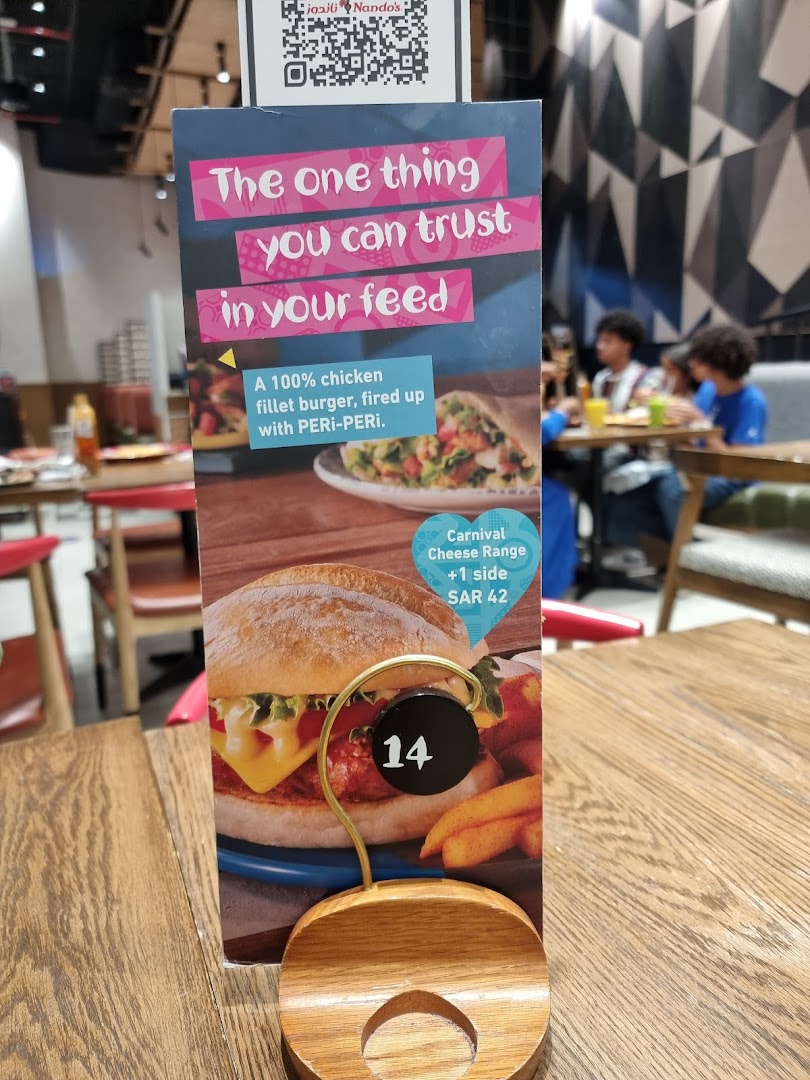A Nando's table tent featuring a chicken burger and fries, with a special offer.