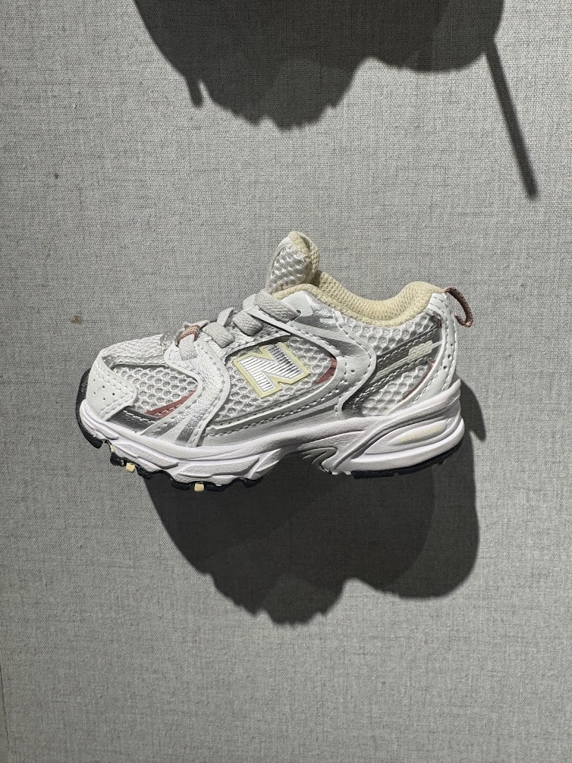 A close-up shot of a white New Balance sneaker with a grey background.