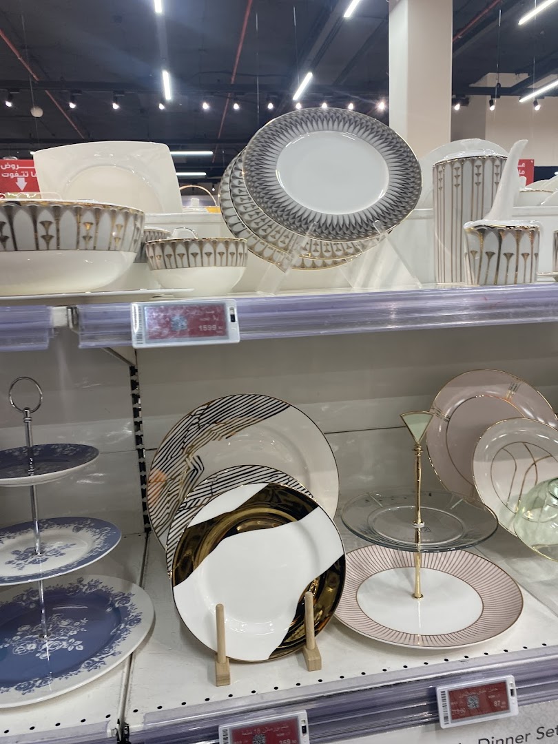 A display of elegant dinnerware, including plates, bowls, and serving dishes, with intricate gold and patterned designs.