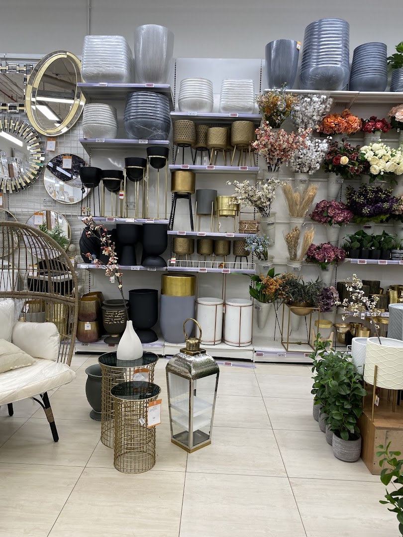 A well-lit store interior showcasing a variety of decorative pots, planters, and home decor items.