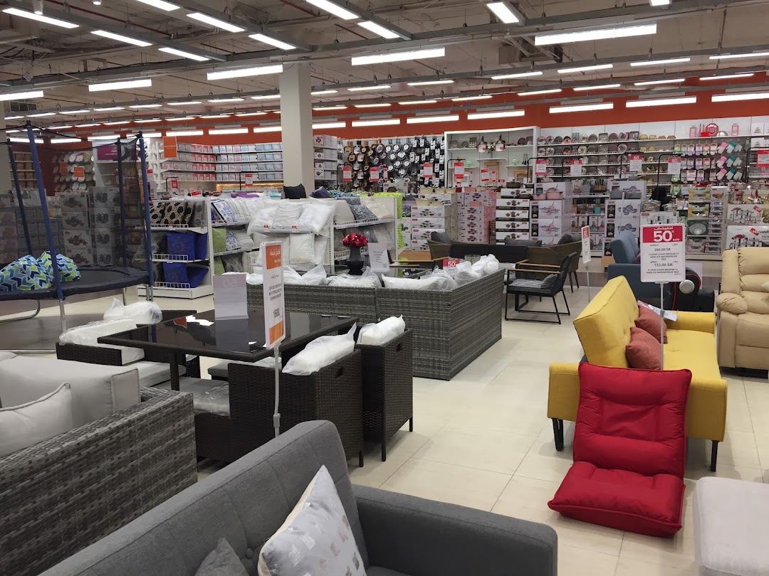 Interior view of a home goods store showcasing furniture, bedding, and kitchenware.