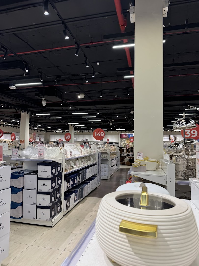 Interior view of a well-lit store showcasing kitchenware and tableware on shelves.