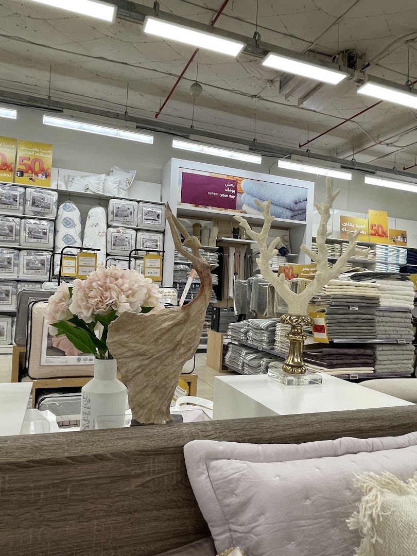 Interior view of a home goods store with bedding, towels, and decorative items.