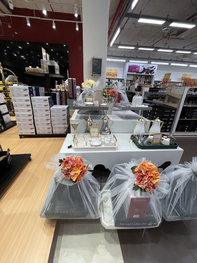 Beautifully packaged tea and coffee sets displayed with floral arrangements in a retail store.