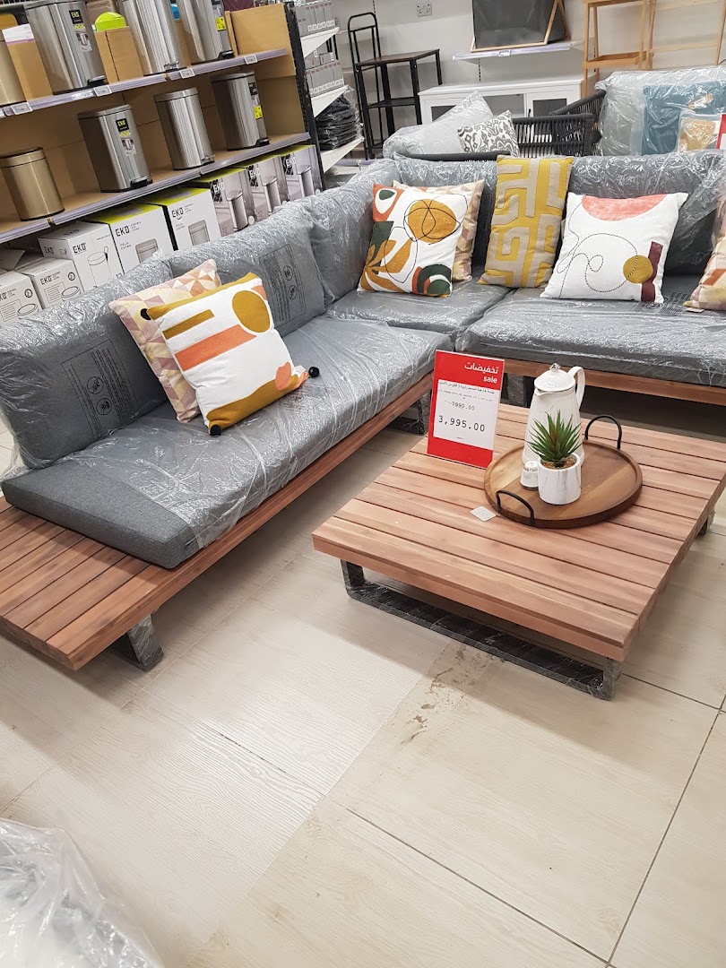 A sectional sofa with decorative pillows and a coffee table in a retail store.