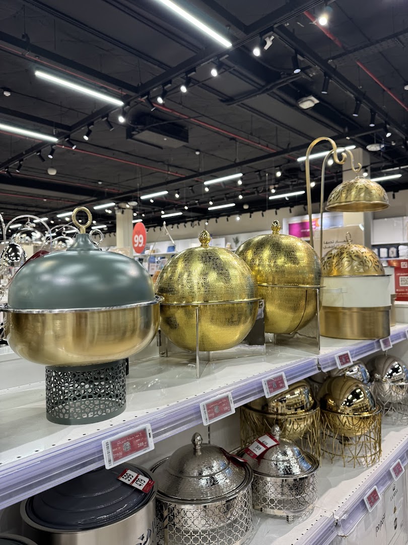 A display of elegant serving dishes and chafing dishes in gold and silver tones.