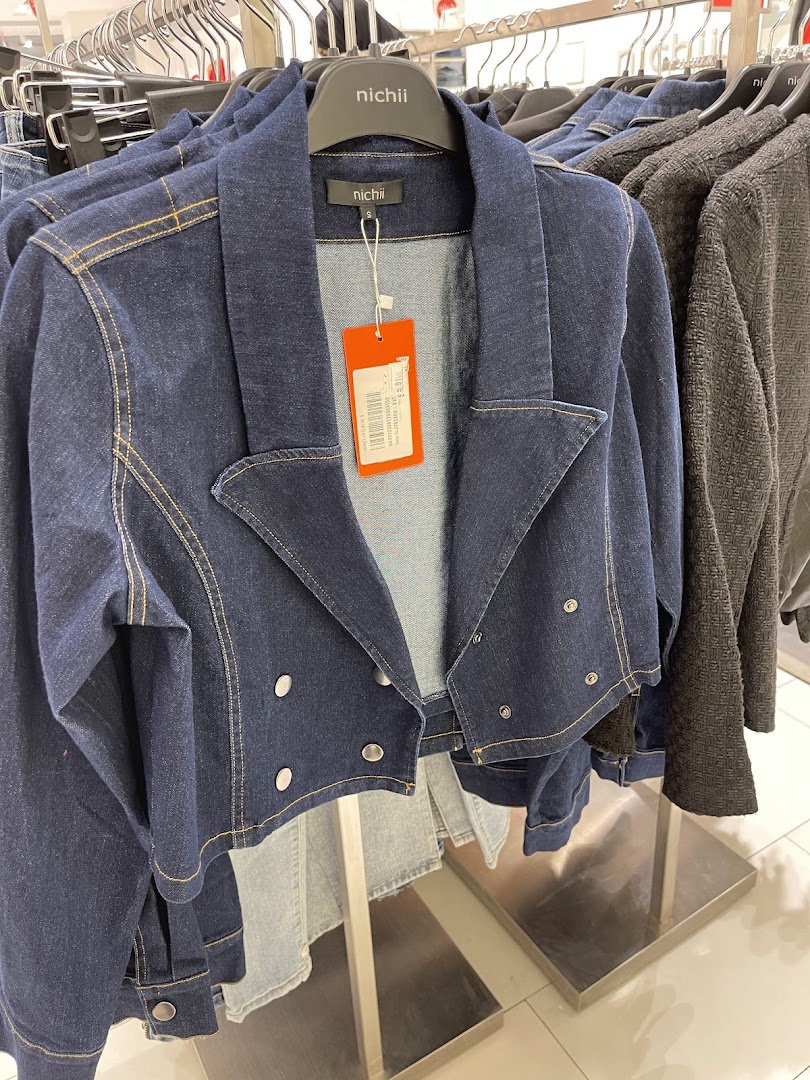 A close-up view of stylish denim jackets on hangers in a retail store.