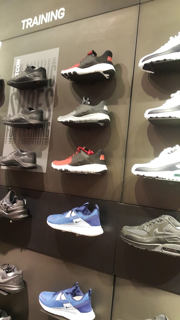 A wall display showcasing various Nike training shoes in different colors and styles.