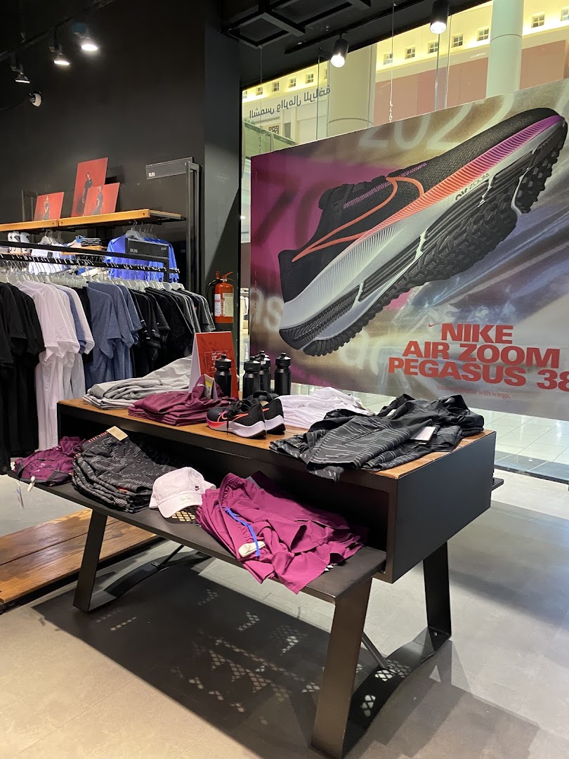 Interior view of a Nike store showcasing apparel and a large advertisement for Nike Air Zoom Pegasus 38.