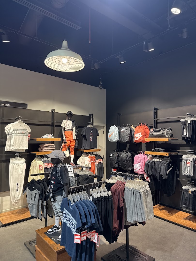 Interior view of a Nike store showcasing apparel and accessories for children and adults.