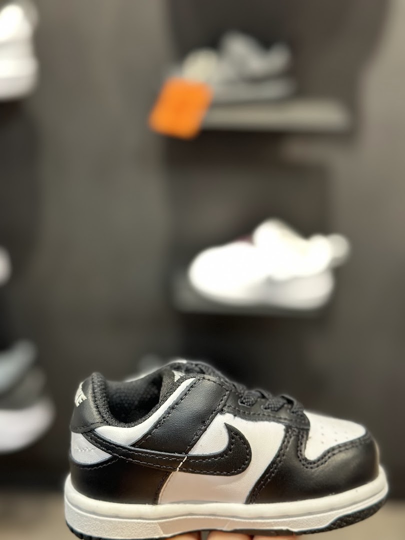 Close-up of a black and white Nike sneaker for children on display.