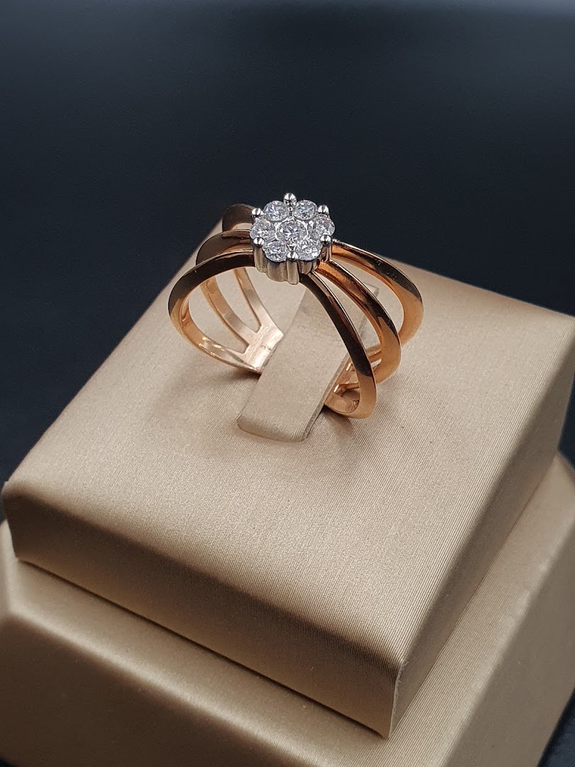 A close-up shot of a rose gold ring with a cluster of diamonds on a display stand.