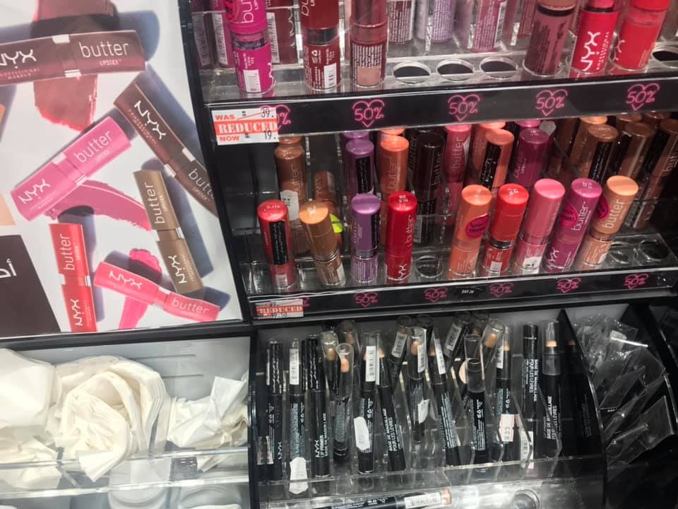 A display of NYX Butter Lipsticks and other makeup products in various shades.