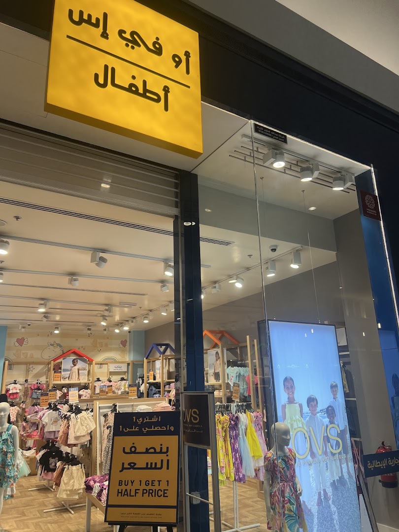 The storefront of OVS Kids, showcasing children's clothing and a 'Buy 1 Get 1 Half Price' promotion.
