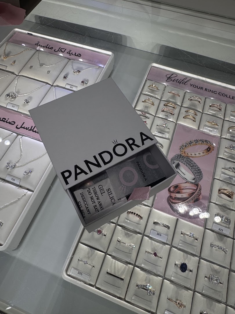 Pandora jewelry display featuring necklaces and rings, with an open gift box.