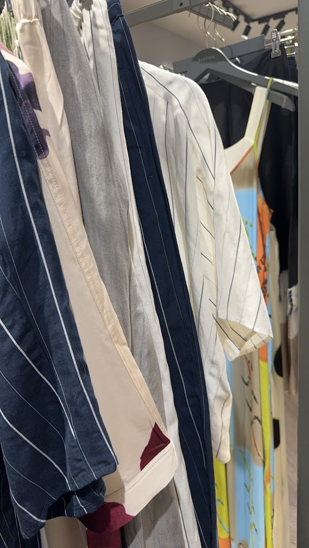 A close-up view of various striped and patterned clothing items hanging on a rack.