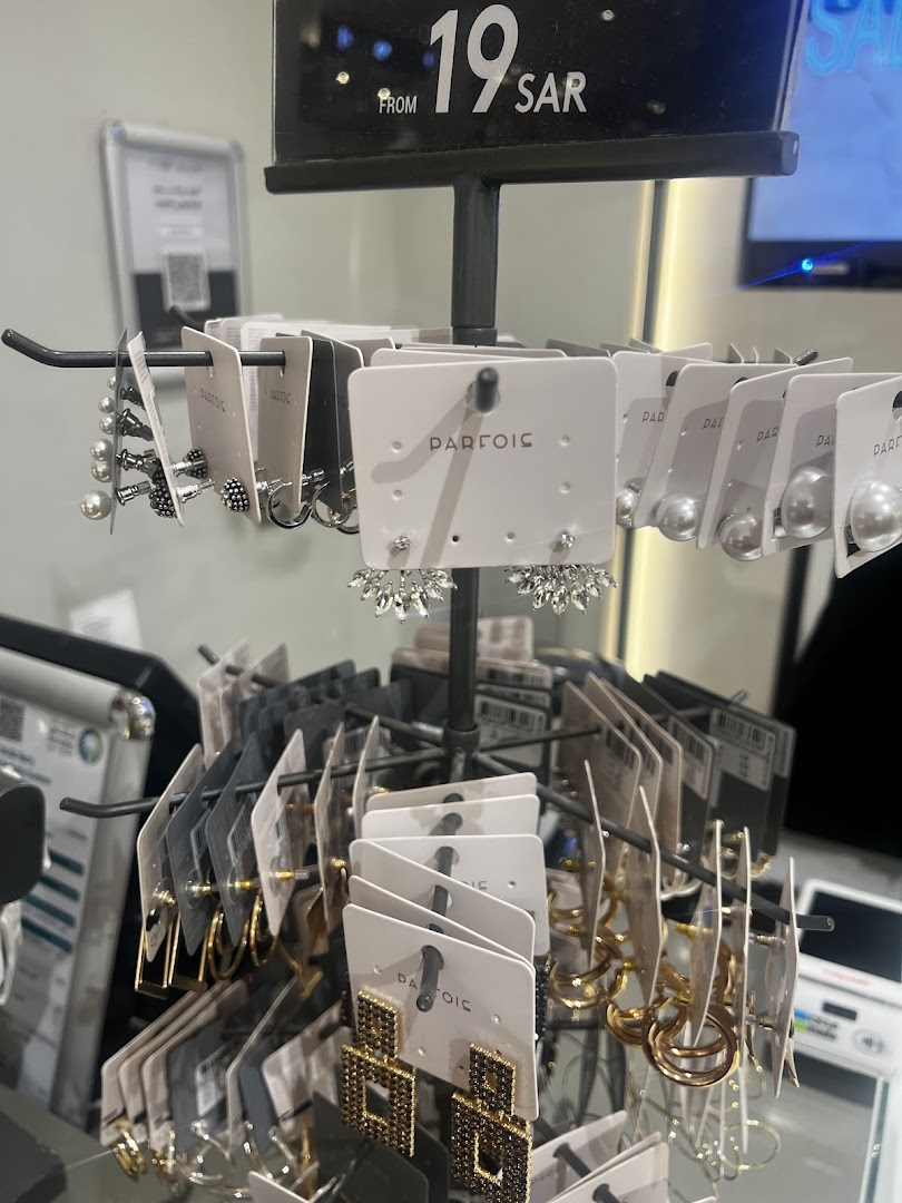 A display rack showcasing various earrings from Parfois, with a price tag indicating 'FROM 19 SAR'.