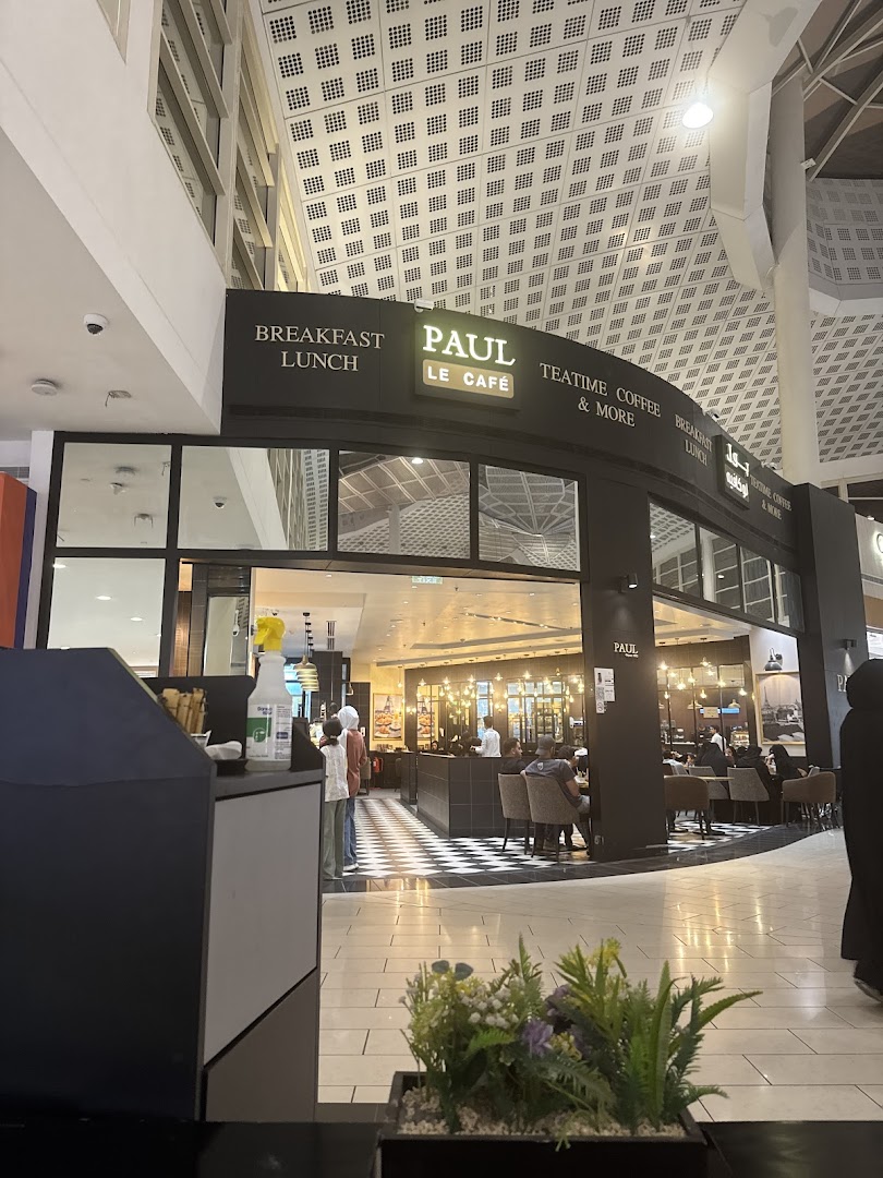 The exterior of Paul Le Cafe, a stylish cafe with seating visible inside.