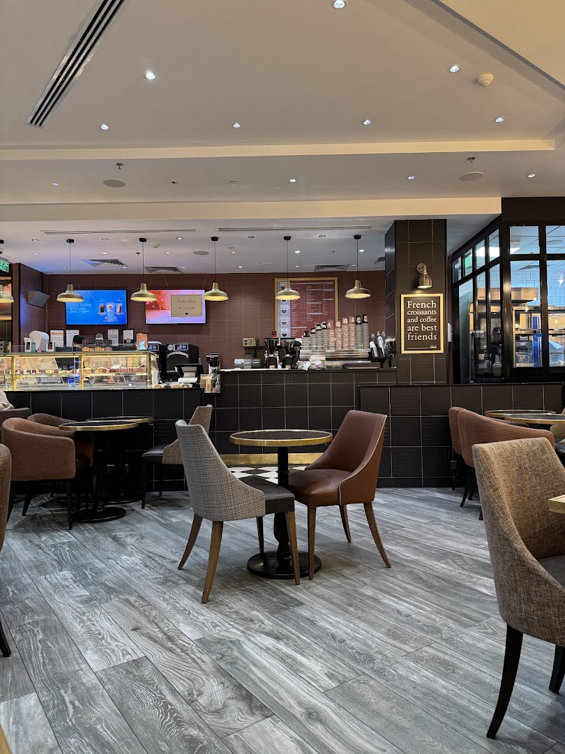 Interior of a cozy cafe with comfortable seating and a counter area.