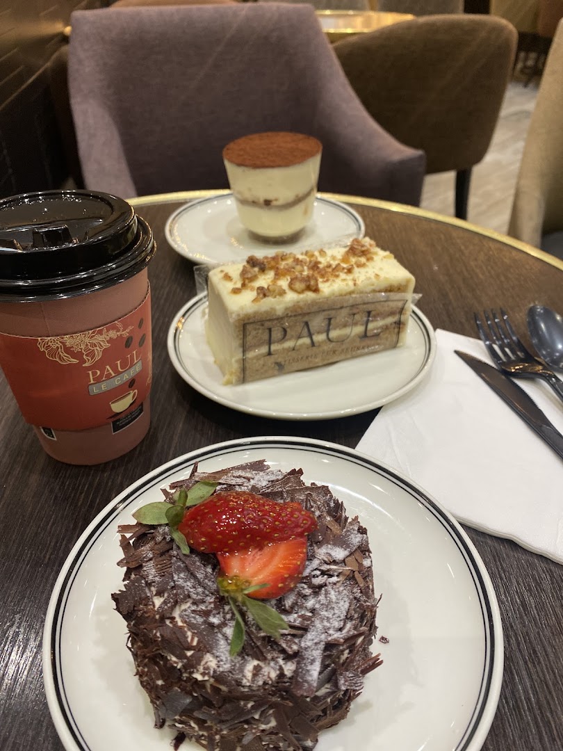 A table at Paul Le Cafe with a coffee cup and three delicious-looking desserts.