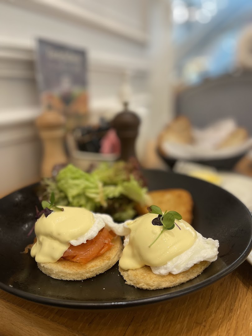A close-up of two delicious Eggs Benedict with smoked salmon and a side salad.