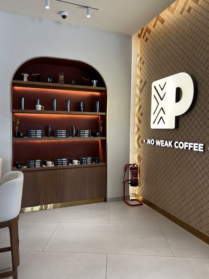 Interior view of Peet's Coffee with shelves displaying merchandise and a prominent logo.