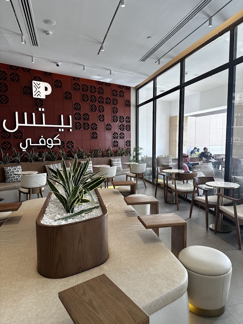 Interior of a modern coffee shop with comfortable seating and a decorative wall.