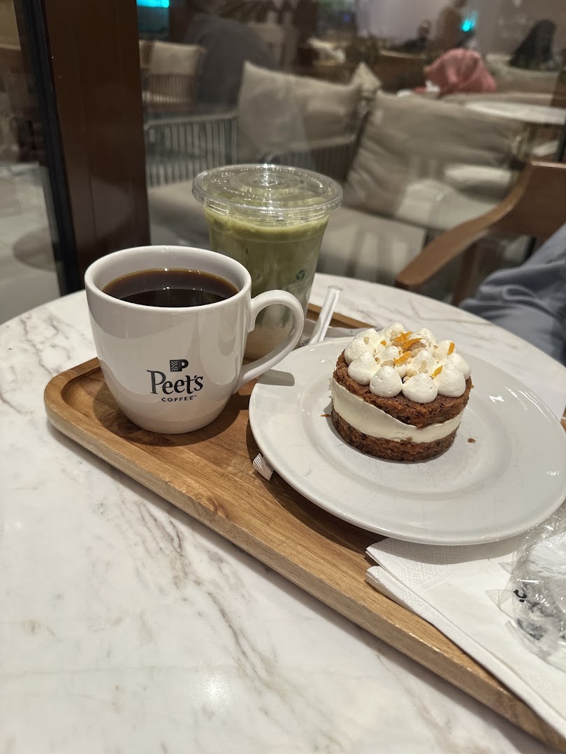 A cup of coffee, a pastry, and a green drink on a tray at Peet's Coffee.